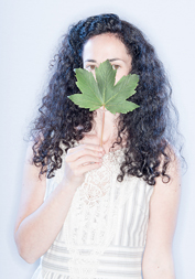 Melanie Challenger holding a green leaf in front of her face.