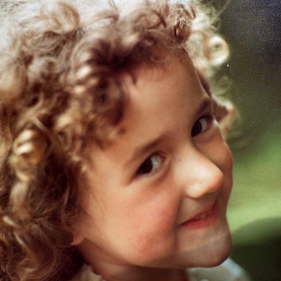 Melanie Challenger as a small child, laughing close to the camera.