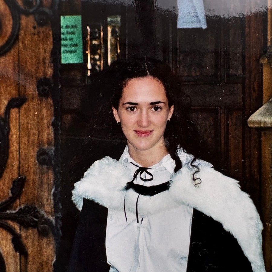 Melanie Challenger in academic dress at an Oxford doorway.
