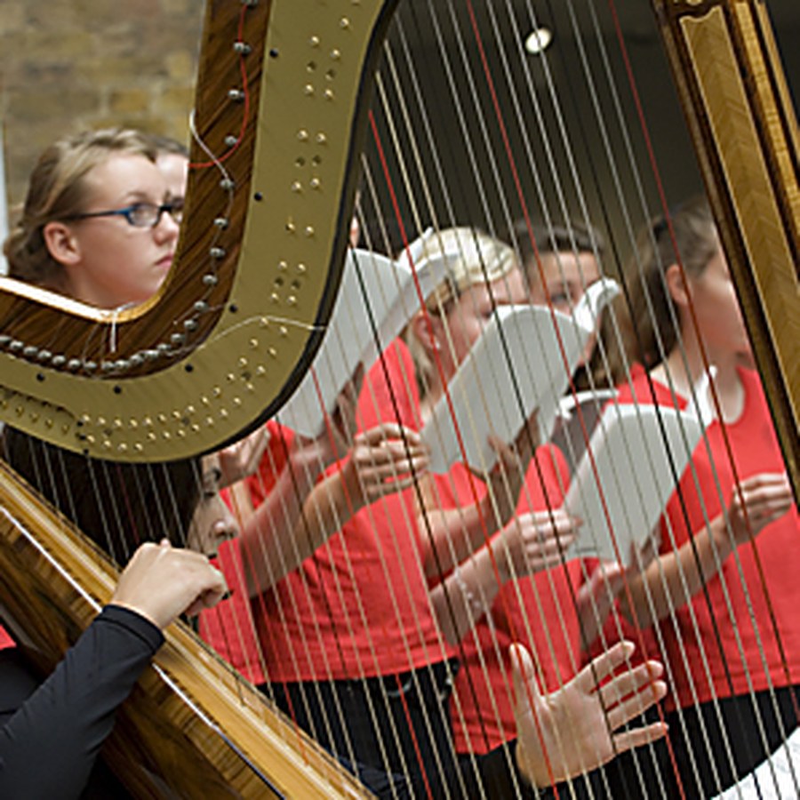 Harpist and youth choir performing Stolen Voices at the Imperial War Museum